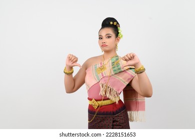 Portrait Young beautiful woman in a costume of the northeastern region with feel bad, she posing thumb down feel upset and grimace on white background, copy space
