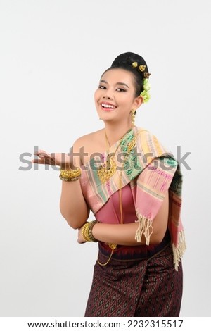 Portrait Young beautiful woman dress up in Thai northeastern region, standing with smile and presenting open palm to insert copy space advertise product with two hand gesture on white background