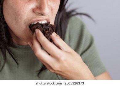 Portrait of young beautiful woman eating chocolate muffin. Enjoy eating. Homemade muffins. - Powered by Shutterstock