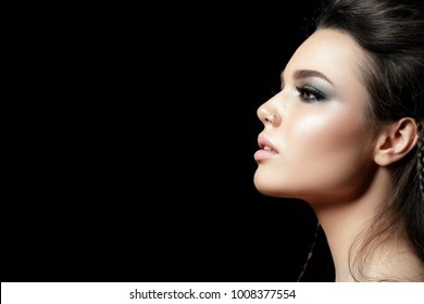 Portrait Of Young Beautiful Woman With Evening Make Up. Model Posing Over Black Background. Silver Smokey Eyes. Classic Makeup Concept. Studio Shot. Copy Space