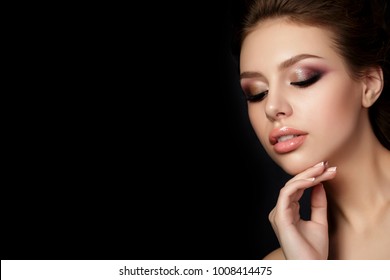 Portrait Of Young Beautiful Woman With Evening Make Up Touching Her Face Over Black Background. Multicolored Smokey Eyes. Luxury Skincare And Modern Fashion Makeup Concept. Studio Shot. Copy Space