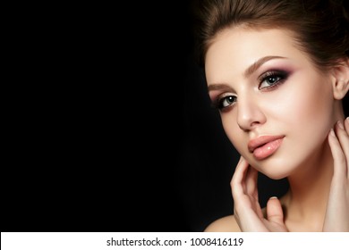 Portrait Of Young Beautiful Woman With Evening Make Up Touching Her Face Over Black Background. Multicolored Smokey Eyes. Luxury Skincare And Modern Fashion Makeup Concept. Studio Shot. Copy Space