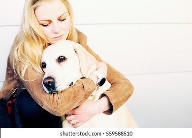 portrait of young beautiful woman hugging golden retriever dog. friendship, pet and human.