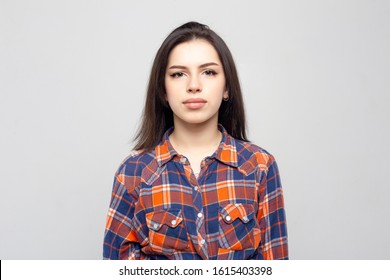 Portrait Young Beautiful Woman Not Smiling In Plaid Shirt Isolated On White-gray Background. Girl With Minimal Natural Make-up On Her Face. The Photo Is Not Retouched With Natural Defects On The Skin.