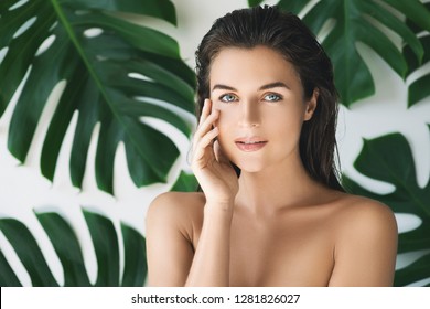 Portrait of young and beautiful woman with perfect smooth skin in tropical leaves. Concept of natural cosmetics and skincare. - Shutterstock ID 1281826027