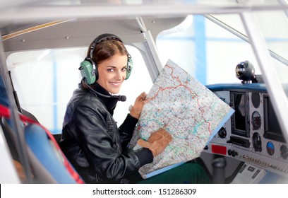 Portrait of young beautiful woman pilot in a airplane. 