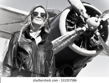 Portrait Of Young Beautiful Woman Pilot In Front Of  Airplane. 