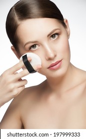 Portrait Of Young Beautiful Woman With Powder Puff. Girl Applying Makeup.