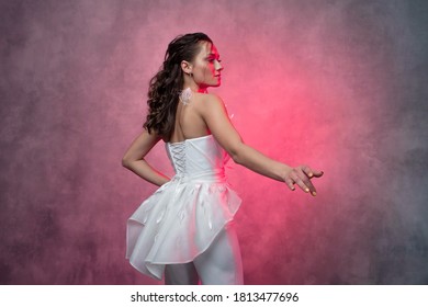 Portrait Of A Young Beautiful Woman In A Smart White Pantsuit, Textured Pink Background. Bride In A Modern Style