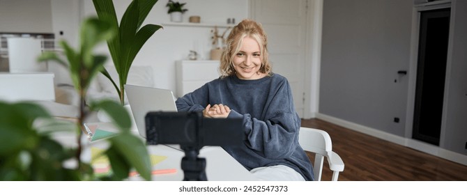 Portrait of young beautiful woman, social media influencer, recording video tutorial, lifestyle vlog, creating content in her room using digital camera. - Powered by Shutterstock