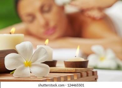 portrait of young beautiful woman in spa environment. blurred face, focused on flower. - Shutterstock ID 124465501