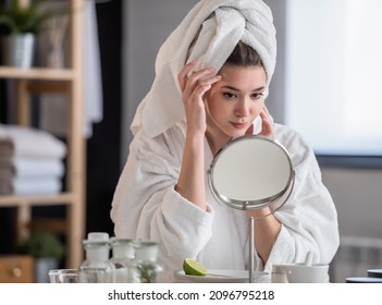Porträt einer jungen schönen Frau, die zu Hause einen Bademantel trägt. tägliche Hautpflege mit Naturkosmetik 