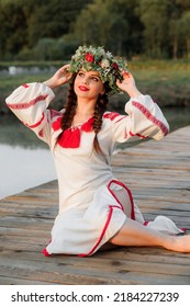 Portrait Of Young Beautiful Woman Wearing A Wreath Of Wild Flowers. Young Pagan Slavic Girl Conduct Ceremony On Midsummer.