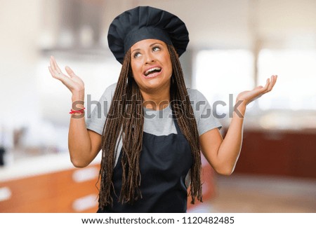 Portrait of a young black baker woman laughing and having fun, being relaxed and cheerful, feels confident and successful