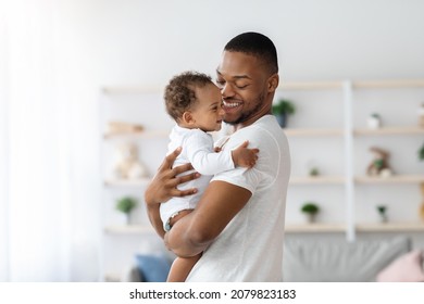 Portrait Of Young Black Father And Infant Child Bonding Together At Home, Loving African American Father Holding His Cute Toddler Baby On Arms And Smiling, Enjoying Paternity Leave Time, Copy Space