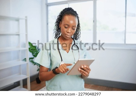 Portrait of a young Black female doctor, using digital tablet, eHealth