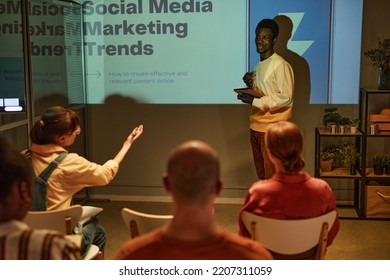 Portrait Of Young Black Man Giving Presentation On Marketing To Team While Standing By Projector Screen In Training Session