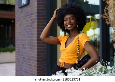 Portrait Of Young Black Woman With Afro Hairstyle Smiling In Urban Background