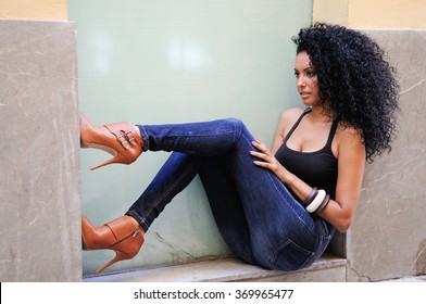 Portrait Of A Young Black Woman, Afro Hairstyle, Wearing Blue Jeans In Urban Background