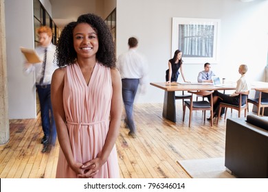 Portrait Of Young Black Woman In A Busy Modern Workplace