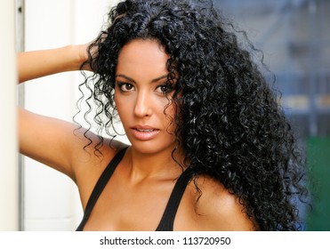 Portrait of a young black woman, model of fashion, with afro hairstyle in urban background
