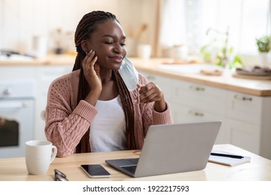 Portrait Of Young Black Woman Scratching Face After Wearing Medical Mask, Sitting At Desk With Laptop At Home, Annoyed African American Lady Having Itchy Skin Symptom Or Allergy, Copy Space