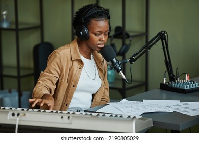 Portrait Of Young Black Woman Singing To Microphone While Recording Music At Home