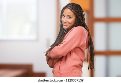 Portrait of a young black woman wearing braids crossing his arms, smiling and happy, being confident and friendly - Shutterstock ID 1120357139