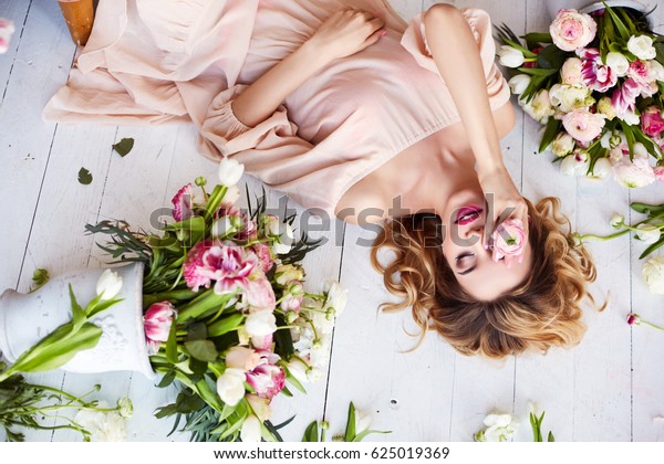 花に若い金髪の女性のポートレート 化粧と髪形をした女性の顔 の写真素材 今すぐ編集