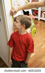 Portrait Of Young Boy Getting Height Measurement In Doorway