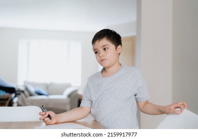 Portrait Young Boy Holding Black Pen Looking Deep In Thought, School Kid Looking Out With Thinking Face. School Kid Doing Homework, Child With Curious Face Standing Alone In Lving Room