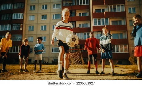 Portrait of a Young Boy Playing Kick-Ups with a Soccer Ball with Friends in a Neighborhood. Happy Multicultural Kids in Post Soviet Eastern European Backyard. Concept of Childhood and Friendship. - Powered by Shutterstock