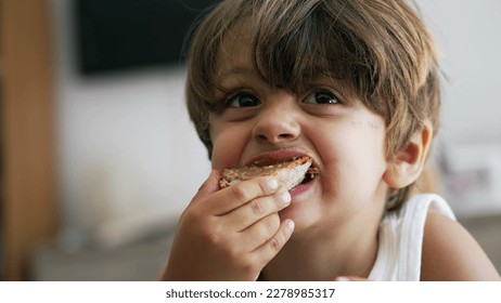 Portrait of a young boy snacking peanut butter bread. Closeup child face eating snack food toast - Shutterstock ID 2278985317