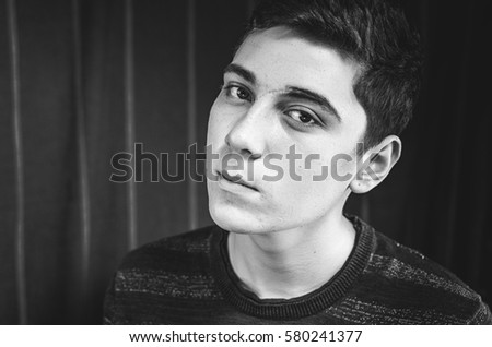 Similar – Boy with a white T-shirt in front of a dark wall