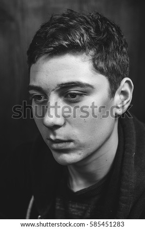 Similar – Boy with a white T-shirt in front of a dark wall