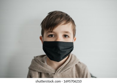 Portrait Of A Young Boy Wearing Black Facemask On White Background