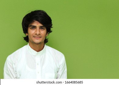 Portrait Of A Young Boy Wearing White Kurta Over Green Wall 