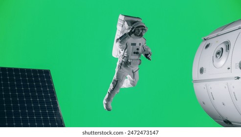 Portrait of a Young And Brave Male Astronaut Posing in a Space Suit on an Isolated Green Screen Background Together with a Mock Up Spaceship, Satellite or a Space Station with Modern Solar Panels - Powered by Shutterstock