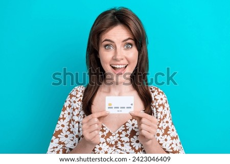 Portrait of young brunette shocked girl invest her savings doing deposit withdrawal profit using ecard isolated on cyan color background
