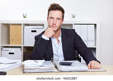 Portrait Of Young Business Man At Desk In Office