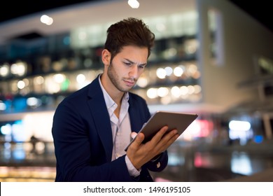 Portrait Of Young Business Man Using His Tablet In A City At Night