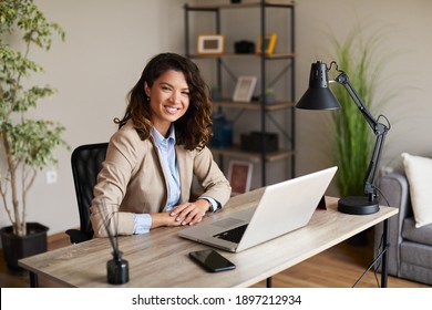 Porträt einer jungen Geschäftsfrau, die an einem Schreibtisch im Büro sitzt