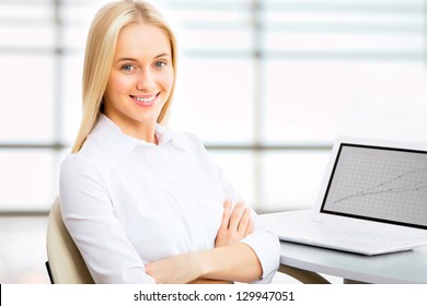 Porträt einer jungen Geschäftsfrau mit Laptop im Büro