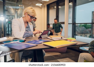 Portrait Of A Young Business Woman Working On A Tablet While Sitting At The Table In The Office. Confident Business Expert. E-commerce, Internet Technology Or Startup Small Business Concept.