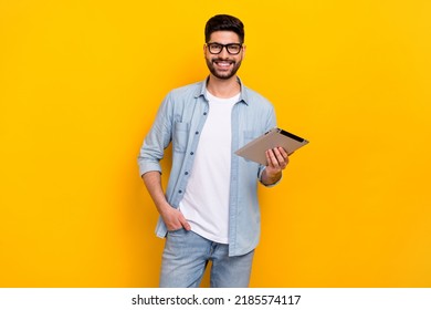 Portrait of young businessman guy hold tablet work assistant use gadgets isolated on yellow color background - Powered by Shutterstock