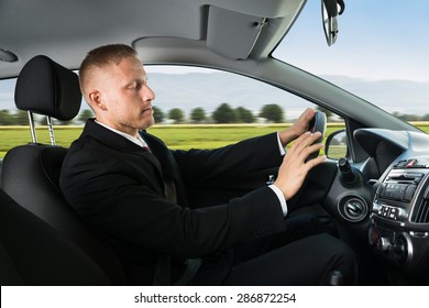 Portrait Of A Young Businessman Sleeping While Driving Car