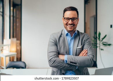 Portrait Of Young Businessman Standing In His Office With Arms Crossed