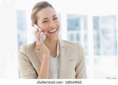 Portrait of a young businesswoman using mobile phone in a bright office