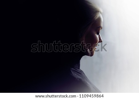 Portrait of a young calm woman in profile. Concept of the inner world and psychology, the dark and light side of personality. Free space for your text or design