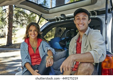 Portrait of young camping couple sitting on car boot, Los Angeles, California, USA - Powered by Shutterstock